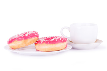two pink donut on a plate next to cup