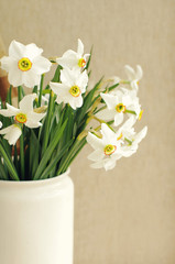 Narcissus flowers bouquet in the white vase in vintage style
