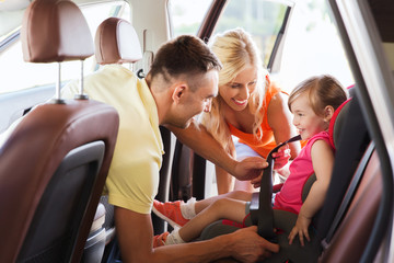 happy parents fastening child with car seat belt