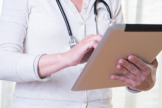female doctor is holding a tablet in her hand