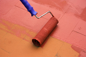 Contract painter painting a floor with a paint roller
