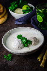 Kibbeh bil laban - arabian yogurt soup with stuffed bulgur cutletson dark background. Selective focus