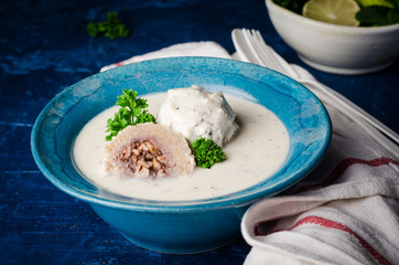 Kibbeh bil laban - arabian yogurt soup with stuffed bulgur cutletson dark background. Selective focus