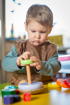 Little caucasian boy playing with Montessori toy