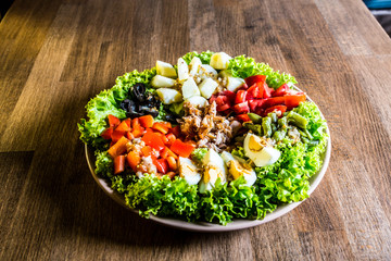nicoise salad over wood background