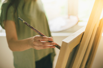 Cropped shot of artist makes paint brush strokes on canvas
