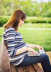 Obraz premium Pregnant woman reading about pregnancy on tablet