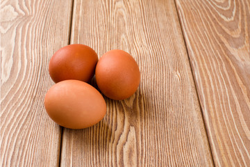Three eggs on a wooden background 