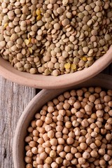 Two clay bowls full of chickpeas and lentils