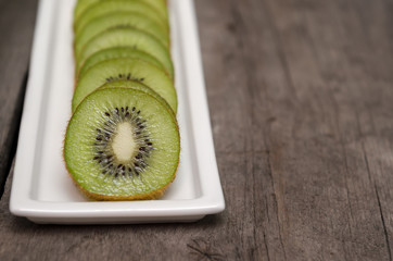 Sliced kiwi fruit on wood background.
