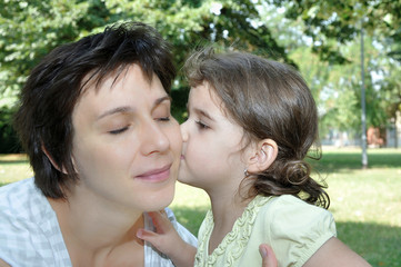Daughter kissing her lovely and happy mother