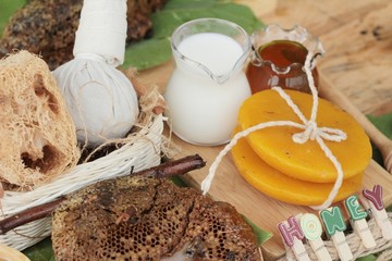 Honey with honeycomb and wax on green leaves.