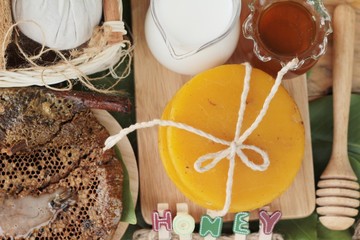 Honey with honeycomb and wax on green leaves.