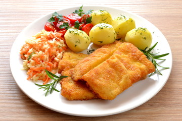 ryba smażona z ziemniakami, surówką i pomidorem
