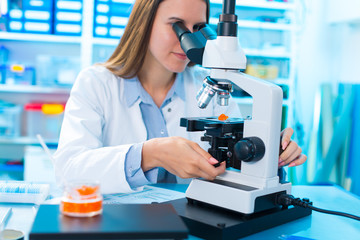 Quality control of food products. Young woman in chemical labora