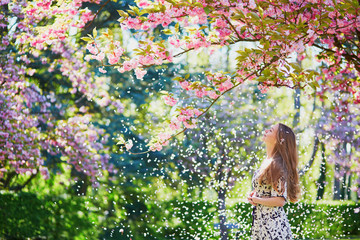 Girl in cherry blossom garden on a spring day