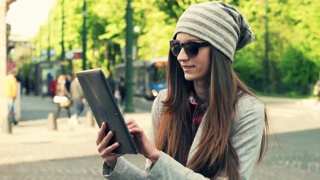 Happy, hipster woman using tablet computer in city 
