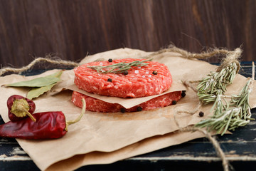 Raw cutlets for burgers on a rustic table