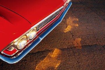Retro red car standing on asphalt road at sunset