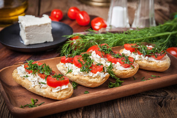 Delicious bruschetta with tomatoes, feta cheese, dill and spice
