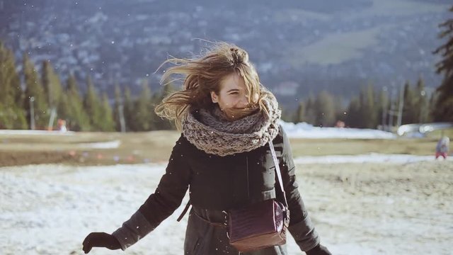 the girl rejoices to snow in the resort in mountains