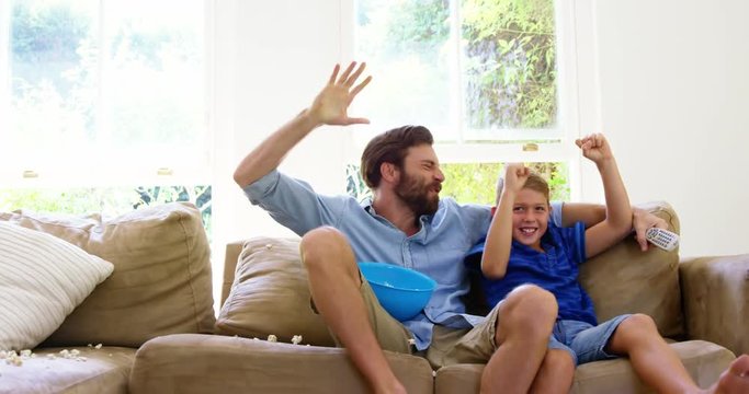 Happy father with son enjoying in front of the television