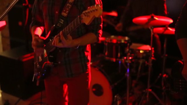 the young music band vigorously plays at a concert