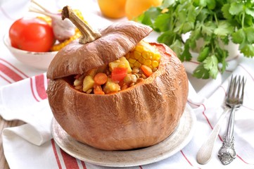 Vegetable stew of potatoes, corn, sweet pepper, onion, tomato with lentils, baked in a pumpkin.