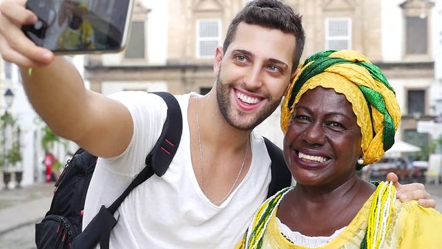 Tourist taking a selfie with a Baiana in the old colonial district of Salvador, Brazil