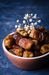 Fresh dates in clay bowl on stone background. Selective focus