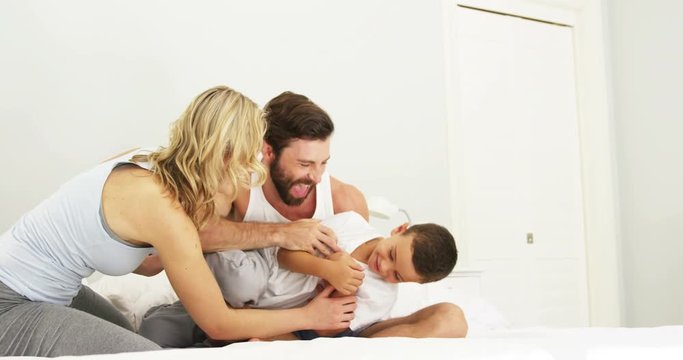 Happy family playing together on a bed