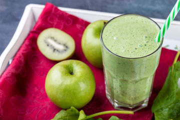 green smoothie with spinach, kiw iand apple on a tray, selective focus