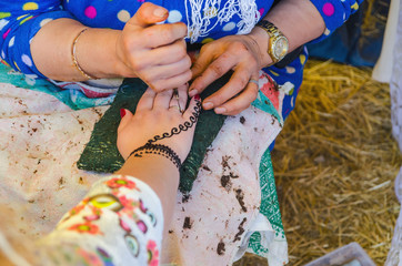 Woman applying henna to make mehndi