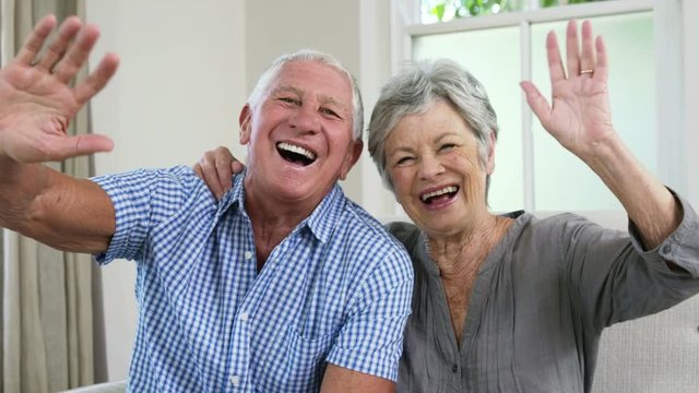 Happy senior couple saying goodbye with their hands