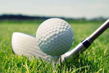 Obrazy na Szkle  Kij golfowy i piłka na tee w trawie
