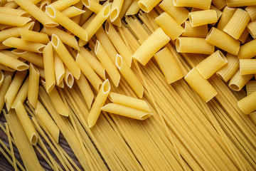 close up portrait of raw homemade italian pasta, macaroni, spaghetti, and fettuccine