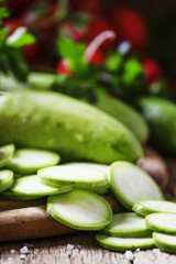 Round zucchini slices and fresh radish, vintage wooden backgroun