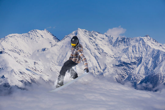 Snowboard rider jumping on mountains. Extreme snowboard freeride sport.