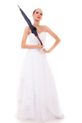 Full length bride in wedding gown holds umbrella