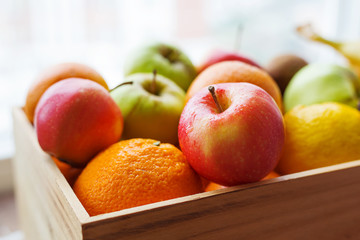 Wooden box full of fresh fruits. Fruit harvest - apples, oranges, lemon.