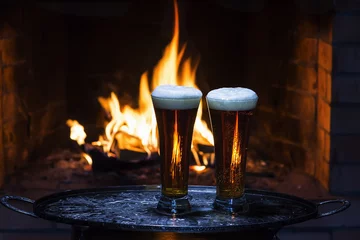 Tuinposter two beers with fireplace on background © alex57111