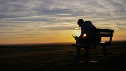 Portrait of a silhouette man on a phone at sunset - 109827429