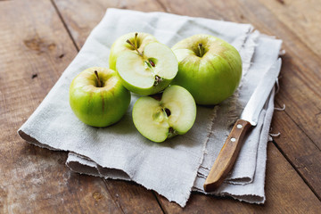 Healthy snack background - green apples on rustic wooden background.