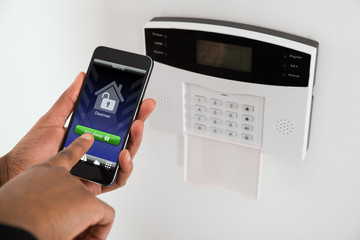 Businesswoman Arming Security System Of Door