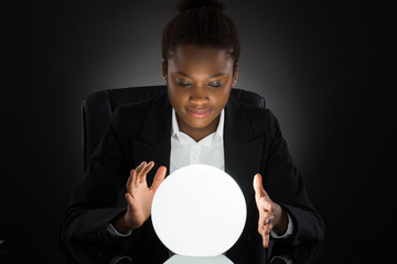 Young Businesswoman Predicting Future With Crystal Ball - obrazy, fototapety, plakaty