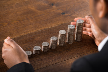 Businessperson Hand Protecting Stacked Coins