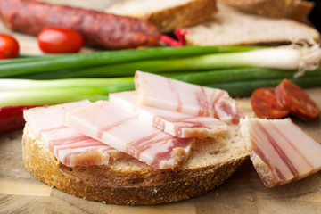 

Lard on bread and other food. Wooden background