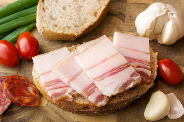 

Lard on bread and other food. Wooden background