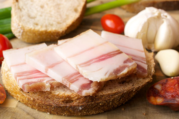 

Lard on bread and other food. Wooden background