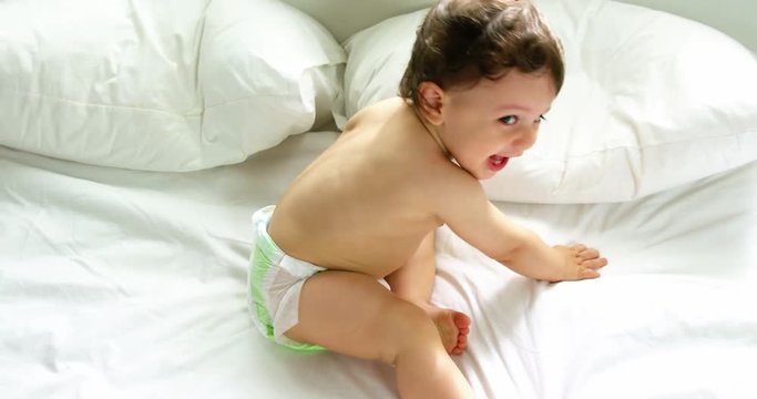 Cute baby playing on a bed 